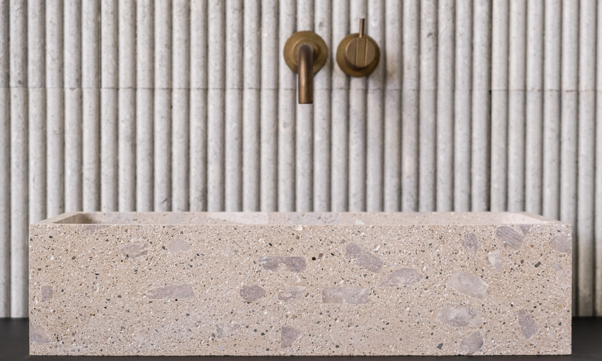 Brass fixtures against the fluted wall